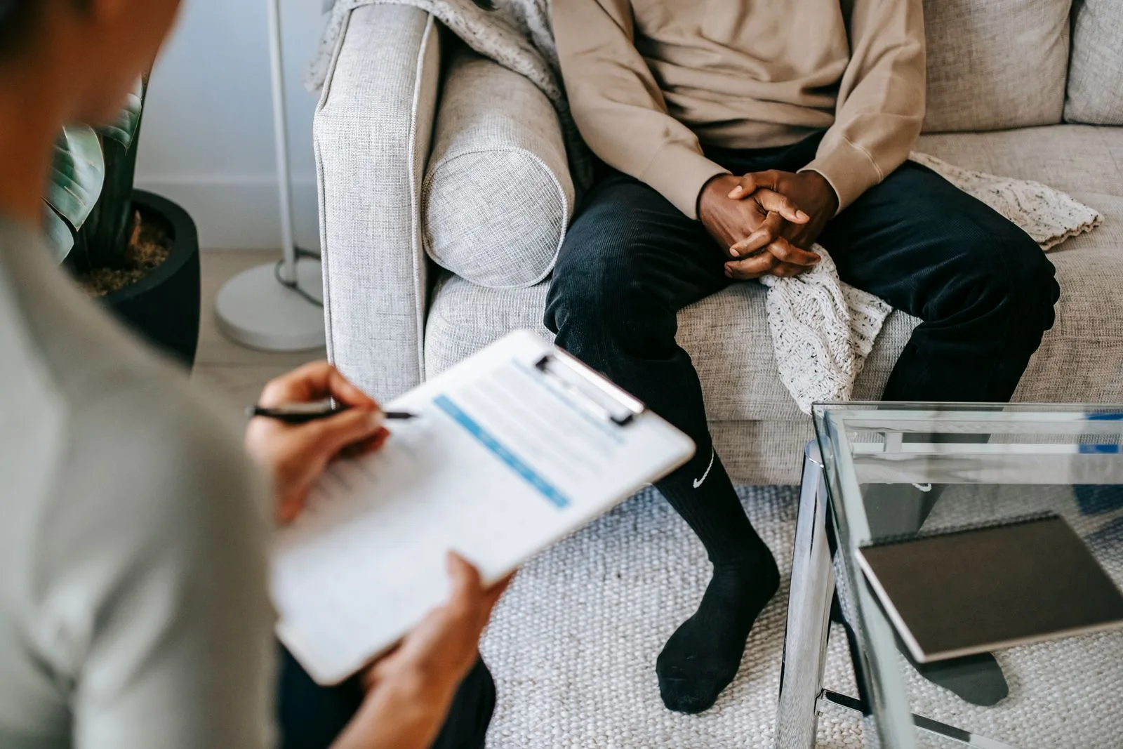 Grupo de adultos conversa alrededor de una mesa con computadoras y documentos para buscar una solución